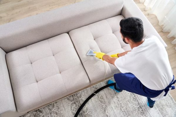 close-up-housekeeper-holding-modern-washing-vacuum-cleaner-cleaning-dirty-sofa-with-professionally-detergent-professional-springclean-home-concept_130111-3787