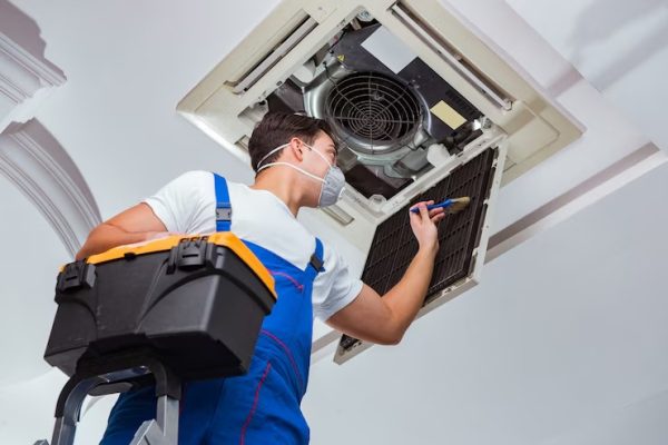 worker-repairing-ceiling-air-conditioning-unit_85869-7023